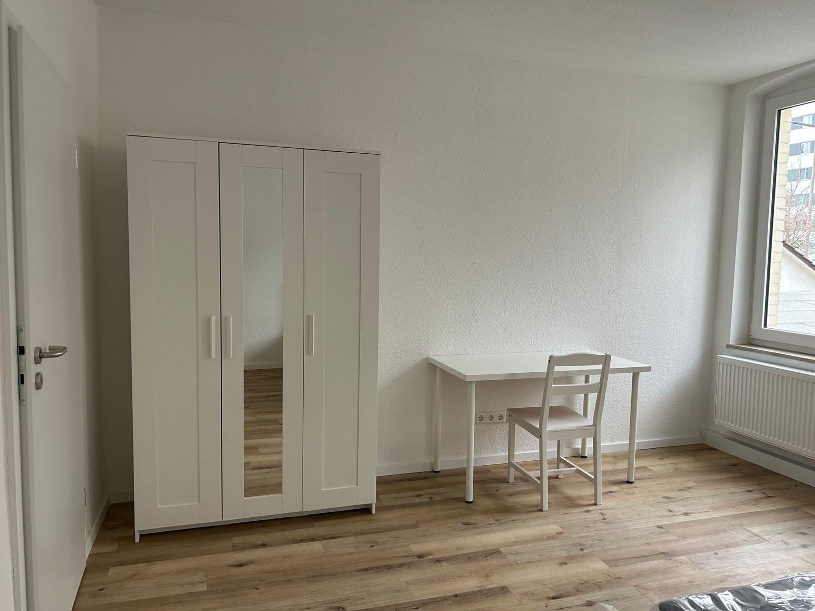 Zimmer mit Kleiderschrank und Schreibtisch